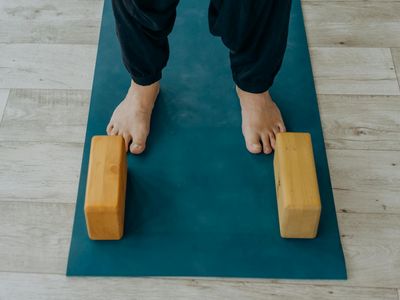 Yoga block and strap on a wooden floor.